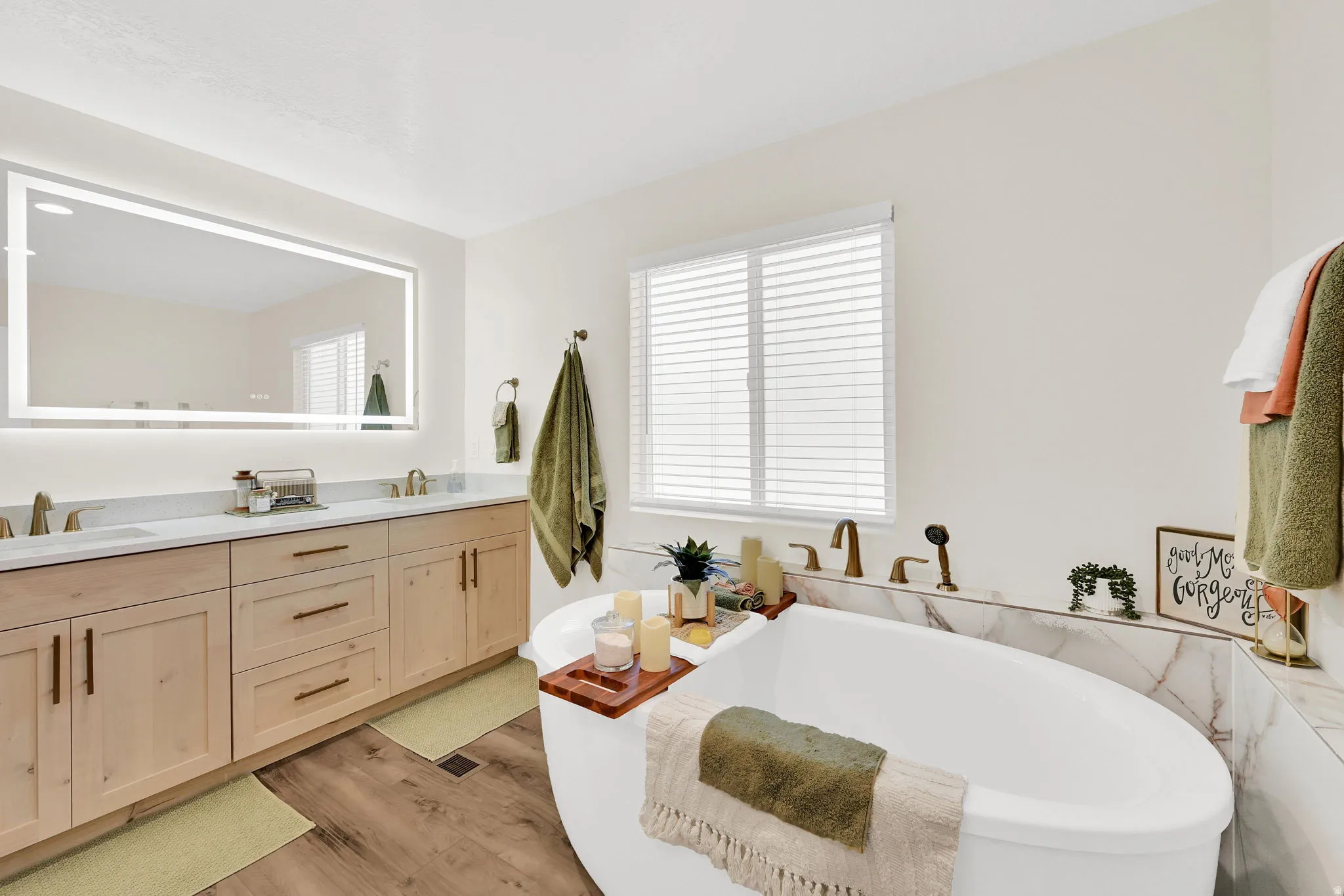 Primary en-suite with freestanding soaker tub, dual-headed shower, and water closet offers a spa-like feel