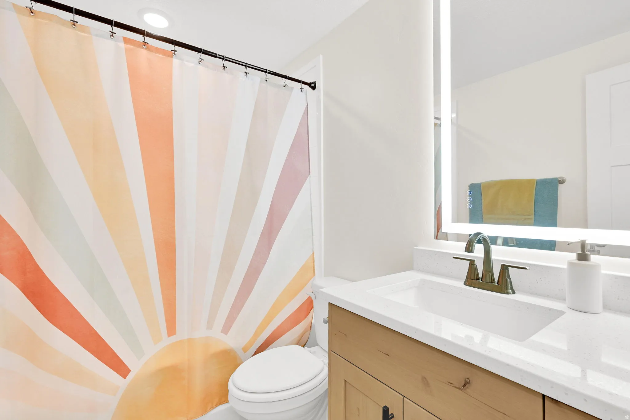 Bathroom featuring a light wood-finish vanity with a white countertop and integrated sink