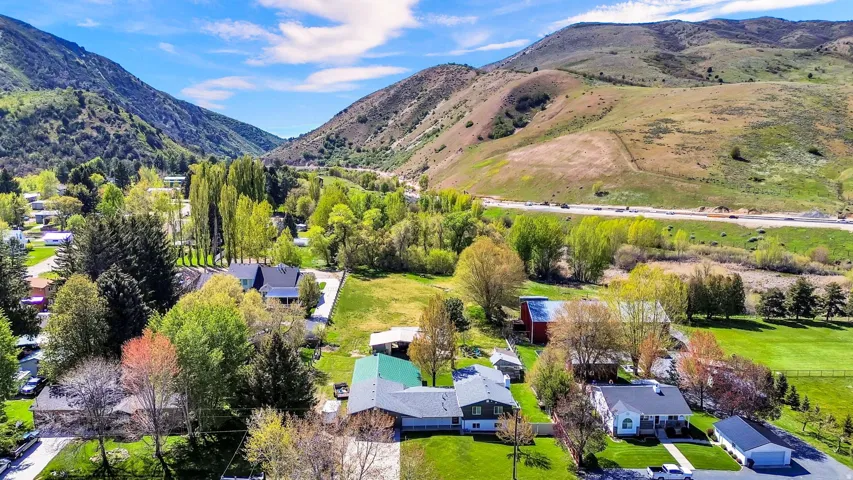 Aerial perspective showcasing multiple properties nestled within a valley surrounded by verdant mountains