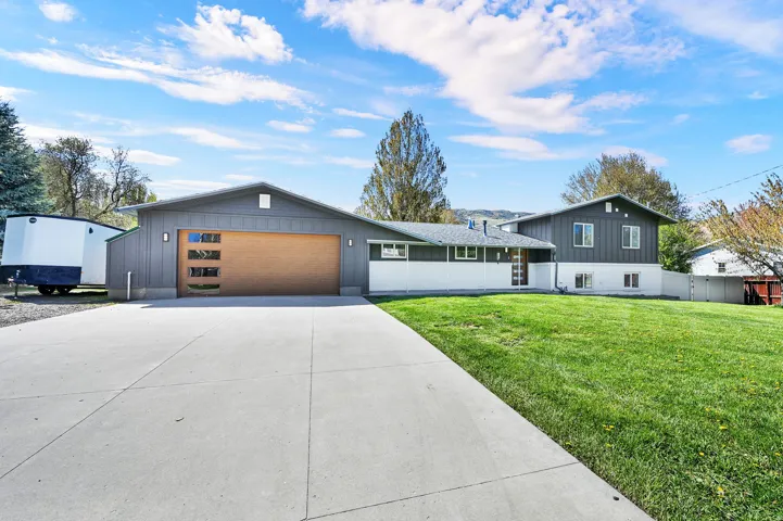 Contemporary split-level residence featuring a charcoal gray and white exterior