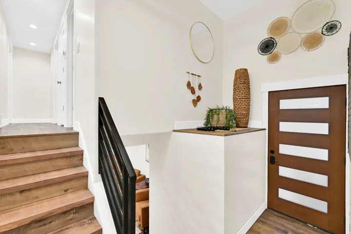 Warm wood-finish stair treads with a black metal handrail