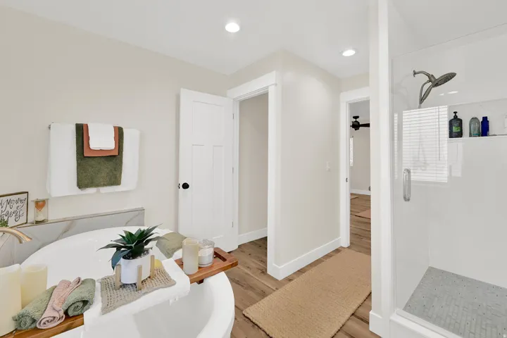 Primary en-suite with freestanding soaker tub, dual-headed shower, and water closet offers a spa-like feel