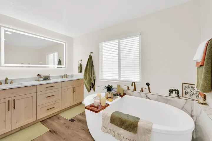 Primary en-suite with freestanding soaker tub, dual-headed shower, and water closet offers a spa-like feel
