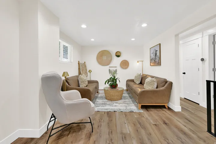 Spacious living area featuring wood-finish flooring, recessed lighting, and a window with blinds