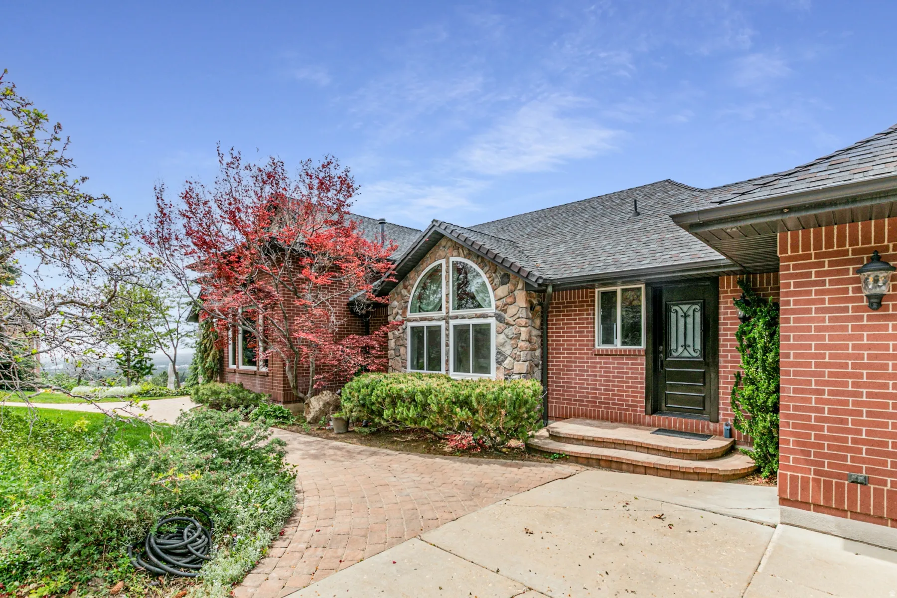 Brick and stone exterior with a dark asphalt shingle roof