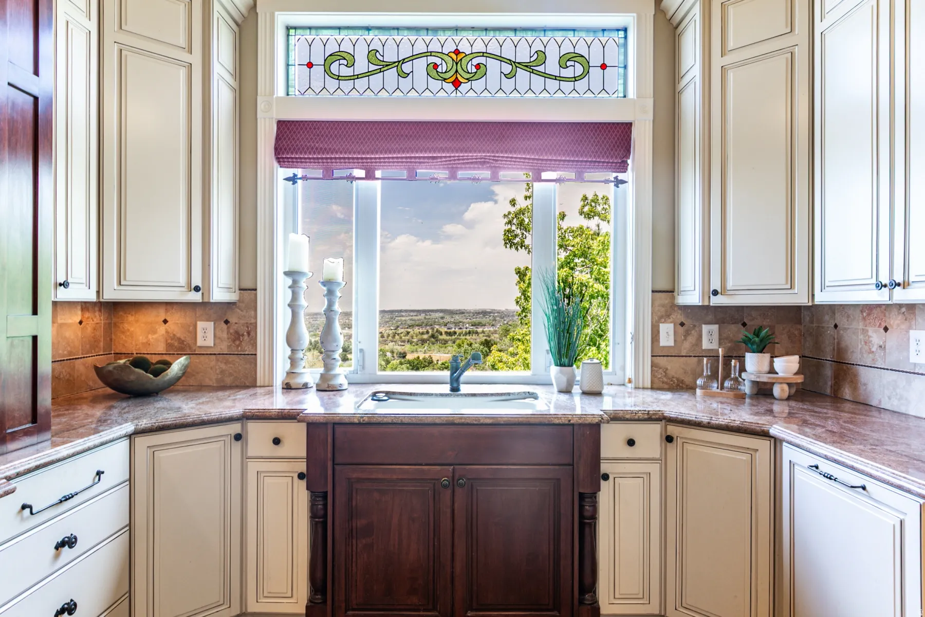 Kitchen window with a built-in sink featuring light-toned cabinetry, a contrasting dark wood base cabinet, and granite countertops