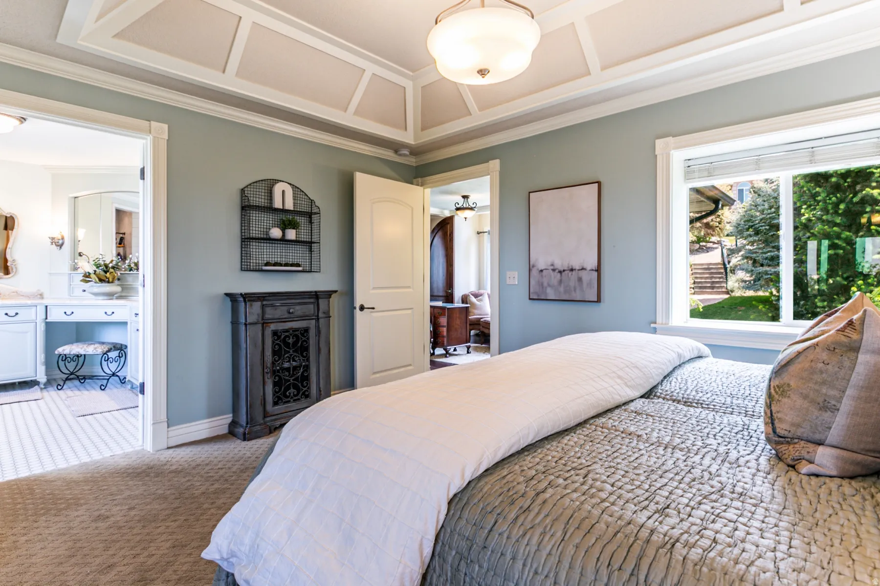 Bedroom featuring a tray ceiling, recessed lighting, and a large window