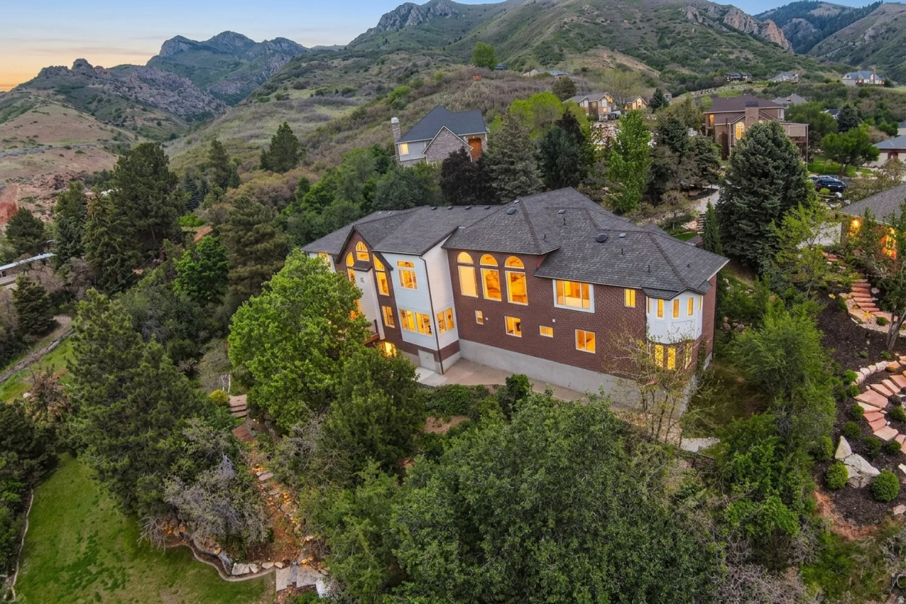 Hillside residence featuring a multi-level design, extensive fenestration, a brick exterior, and a prominent bay window