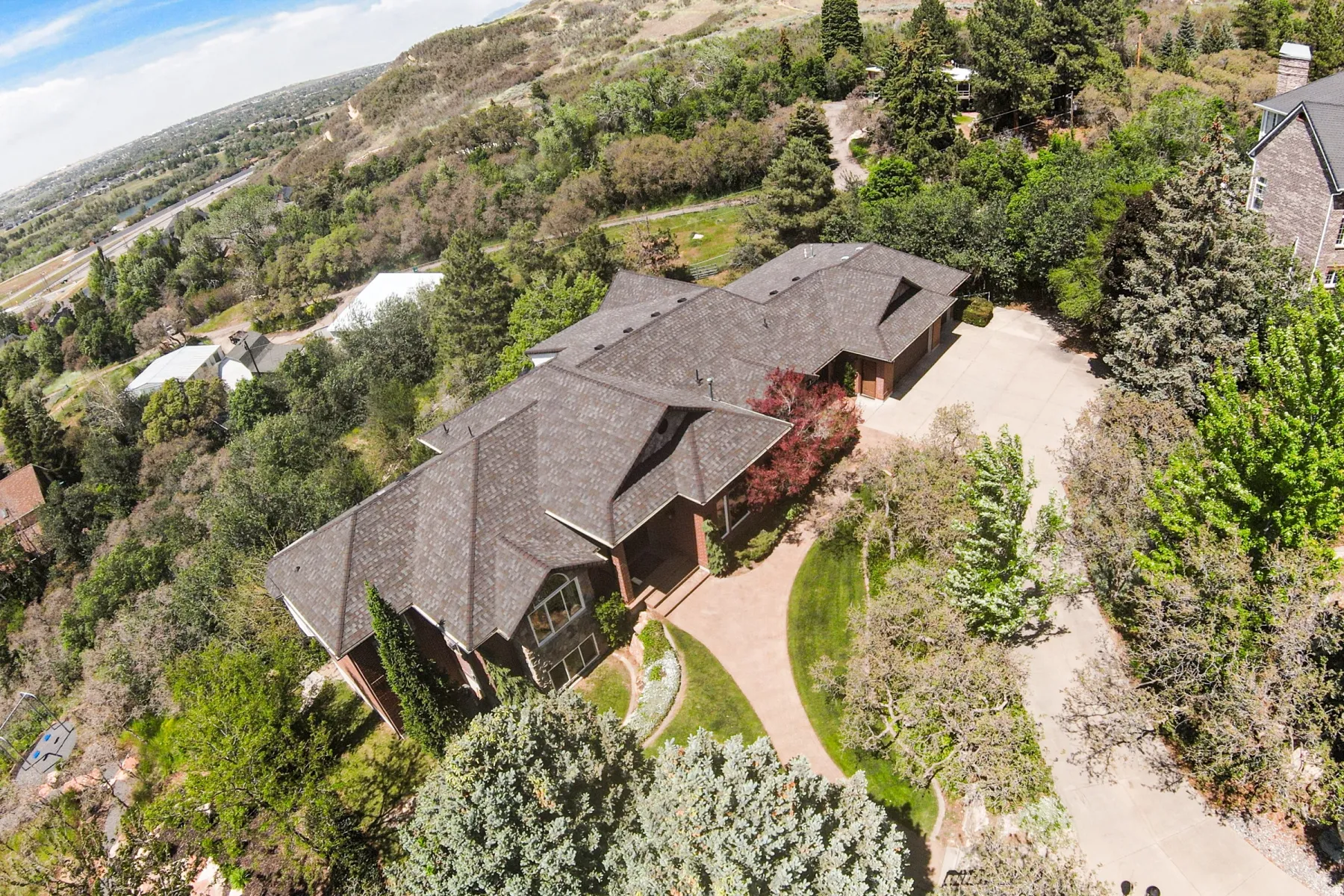 Expansive property featuring a multi-level residence with a shingle roof and multiple gables