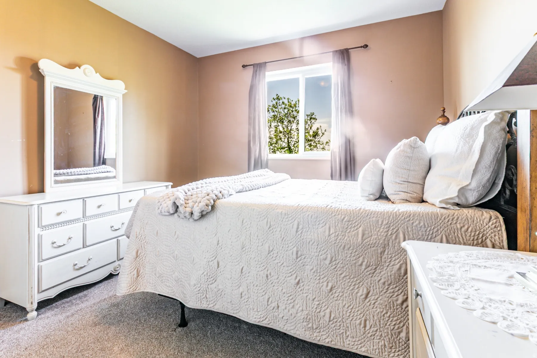 Double-hung window with a white frame and natural light, complemented by light-colored walls and carpeted flooring
