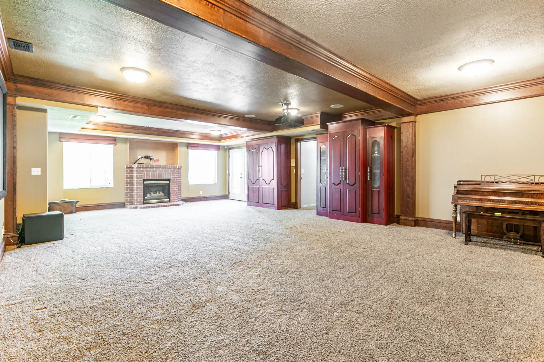 Spacious living area featuring a brick fireplace, multiple windows with blinds, recessed lighting, and a ceiling fan