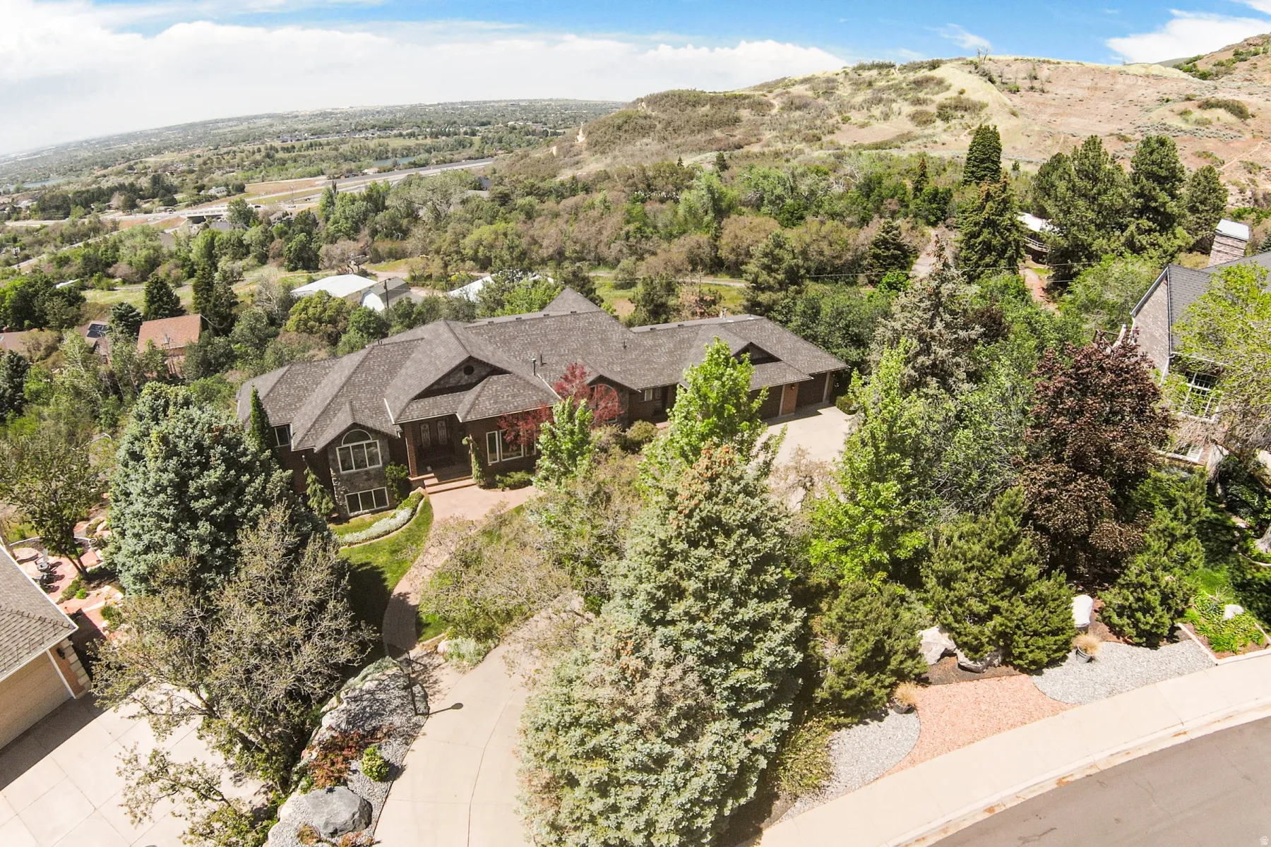Sprawling residential property featuring a multi-gabled roofline and a brick-paved driveway