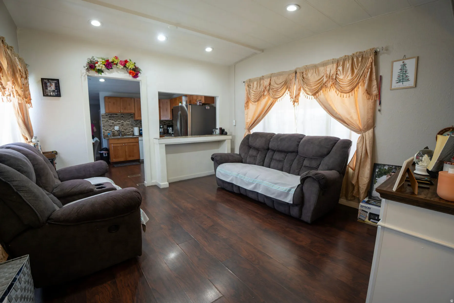 Living area featuring wood-finish flooring, recessed lighting, and a pass-through window to the kitchen