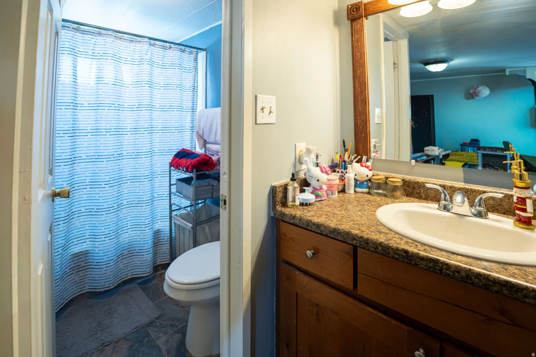 Bathroom vanity featuring an integrated sink, laminate countertop, and wood-finish cabinetry
