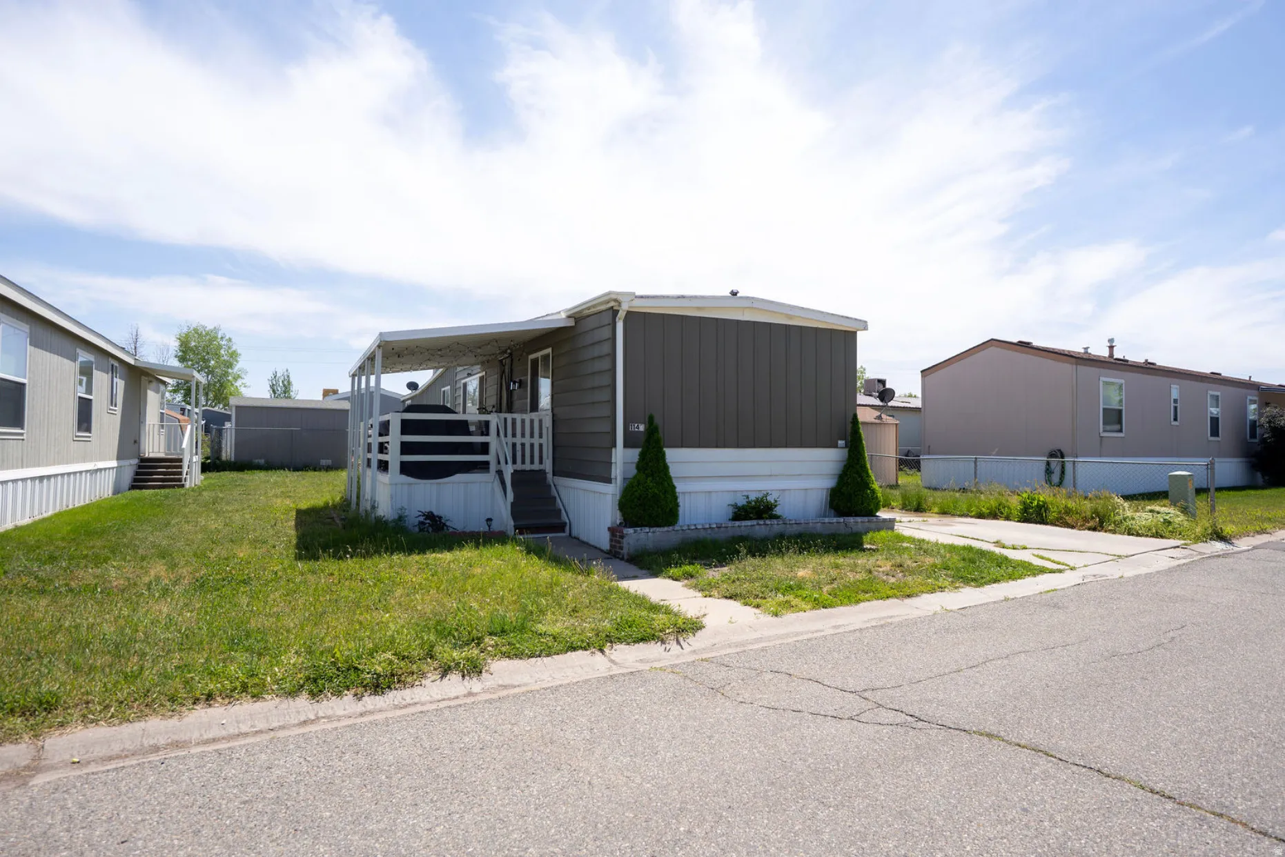 Manufactured home featuring covered porch entry and a two-tone exterior with a white perimeter