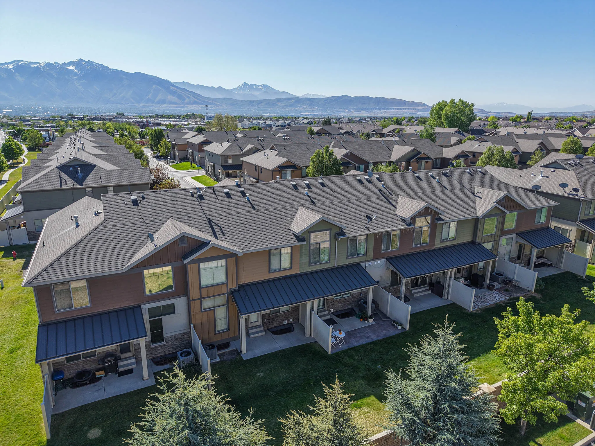 Townhome row with pitched shingle roofs and covered patios