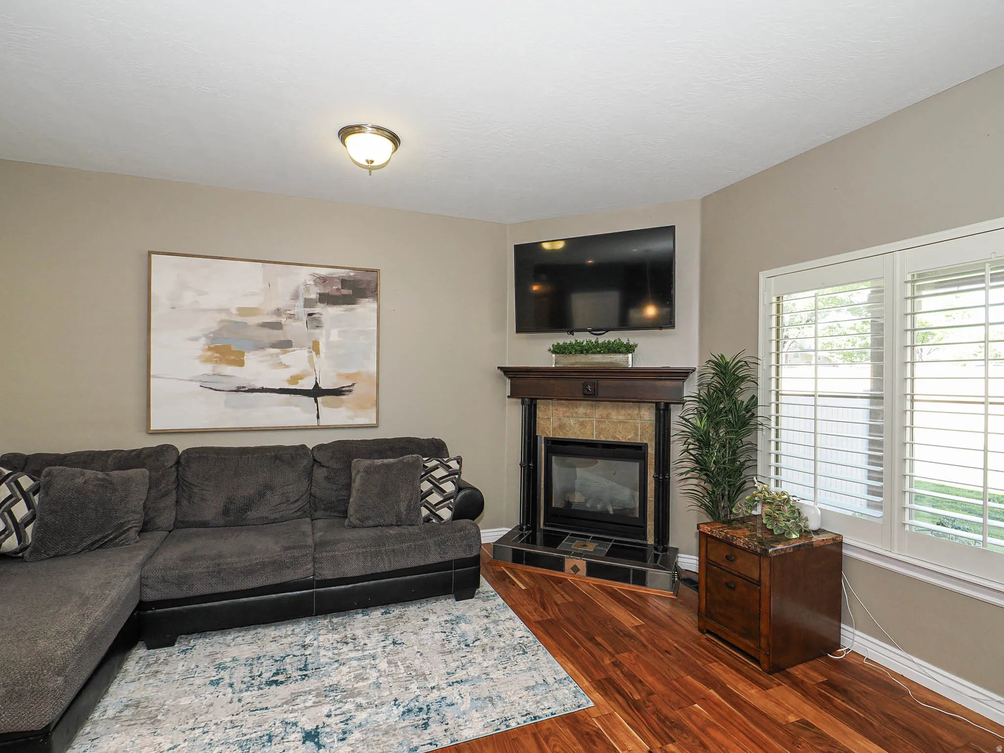 Corner fireplace with a wood-finish mantel and stone surround
