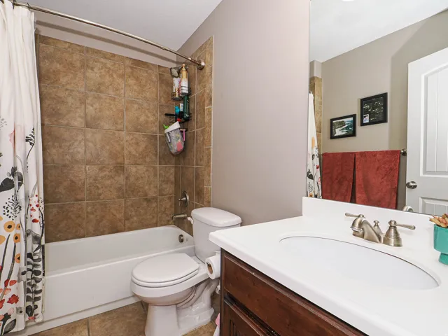 Full bathroom featuring a white vanity with an oval undermount sink, brushed nickel faucet, and a large wall-mounted mirror