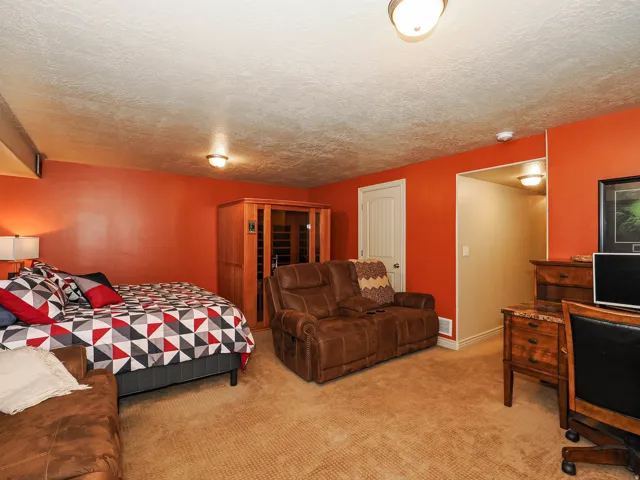 Carpeted room with a textured ceiling and warm-toned walls