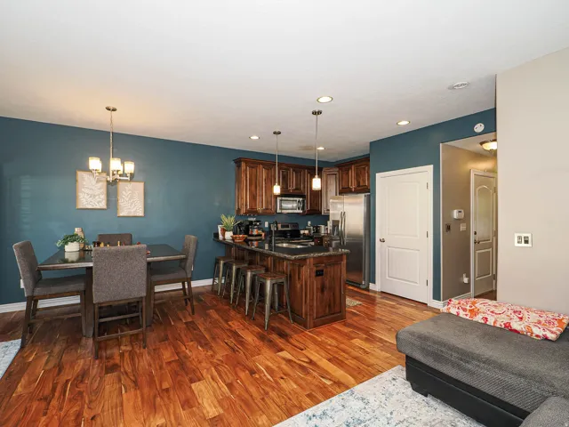 Open-concept living space featuring wood-finish flooring, recessed lighting, and a kitchen island with pendant lighting