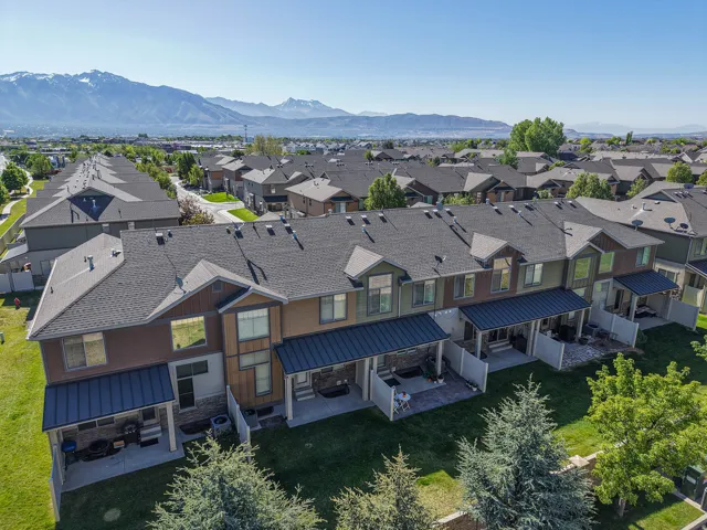 Townhome row with pitched shingle roofs and covered patios