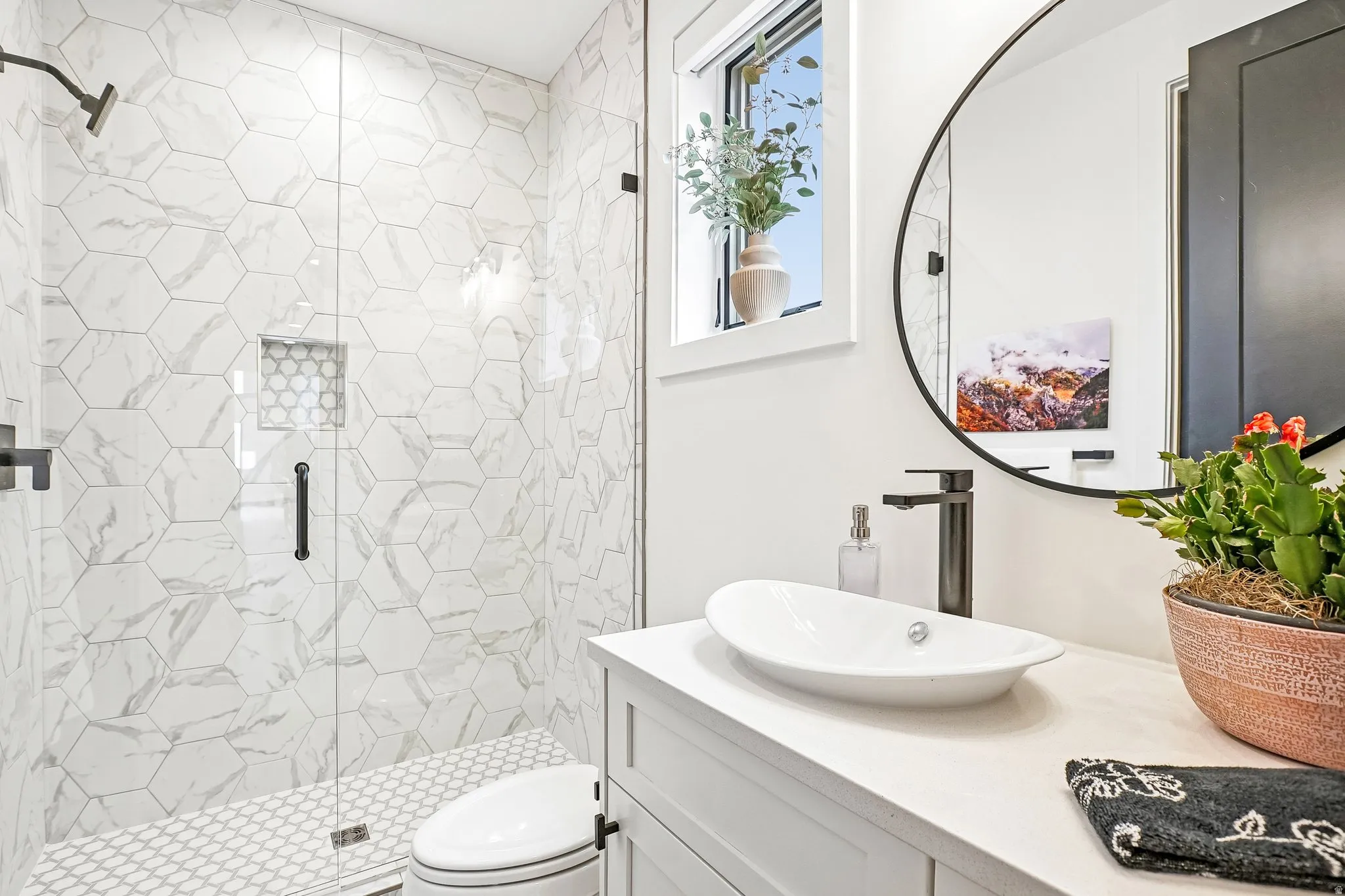 Bathroom featuring a glass-enclosed shower with hexagonal tile, a built-in shower niche, and a white penny-tile floor