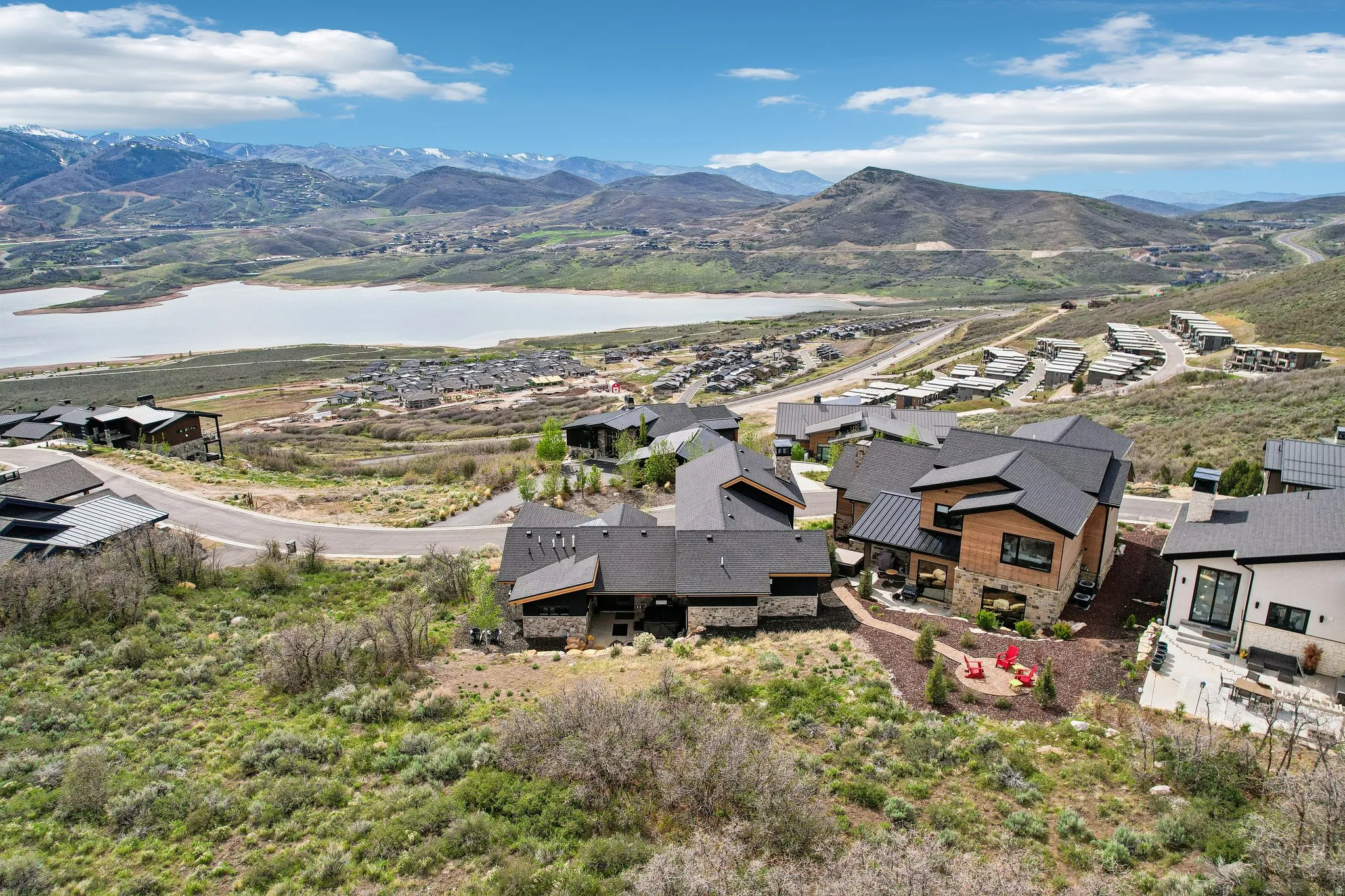 Modern mountain residence with a multi-level design, stone and wood-panel exterior accents, and a dark metal roof