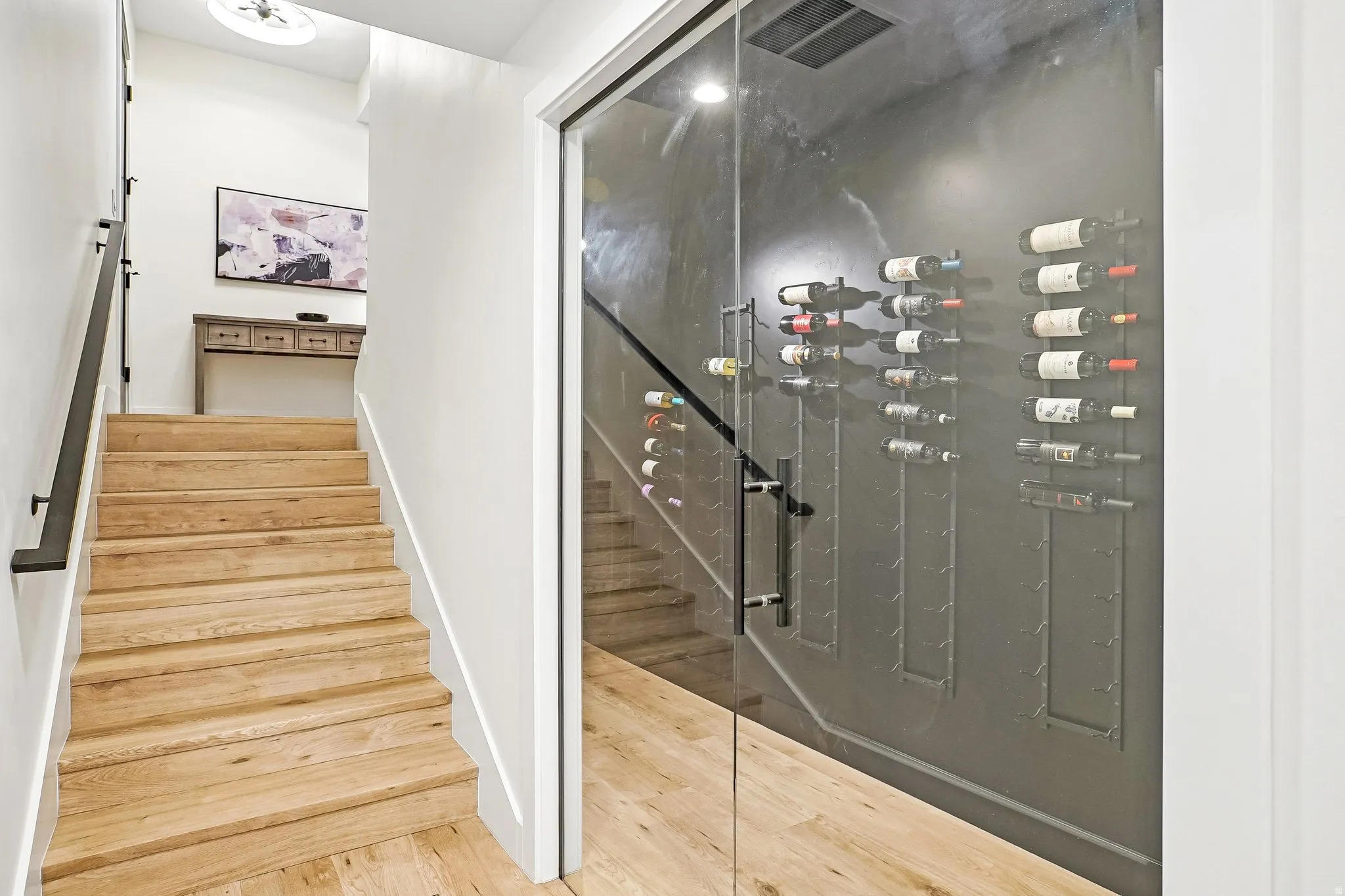 Custom glass-enclosed wine storage featuring wall-mounted racks