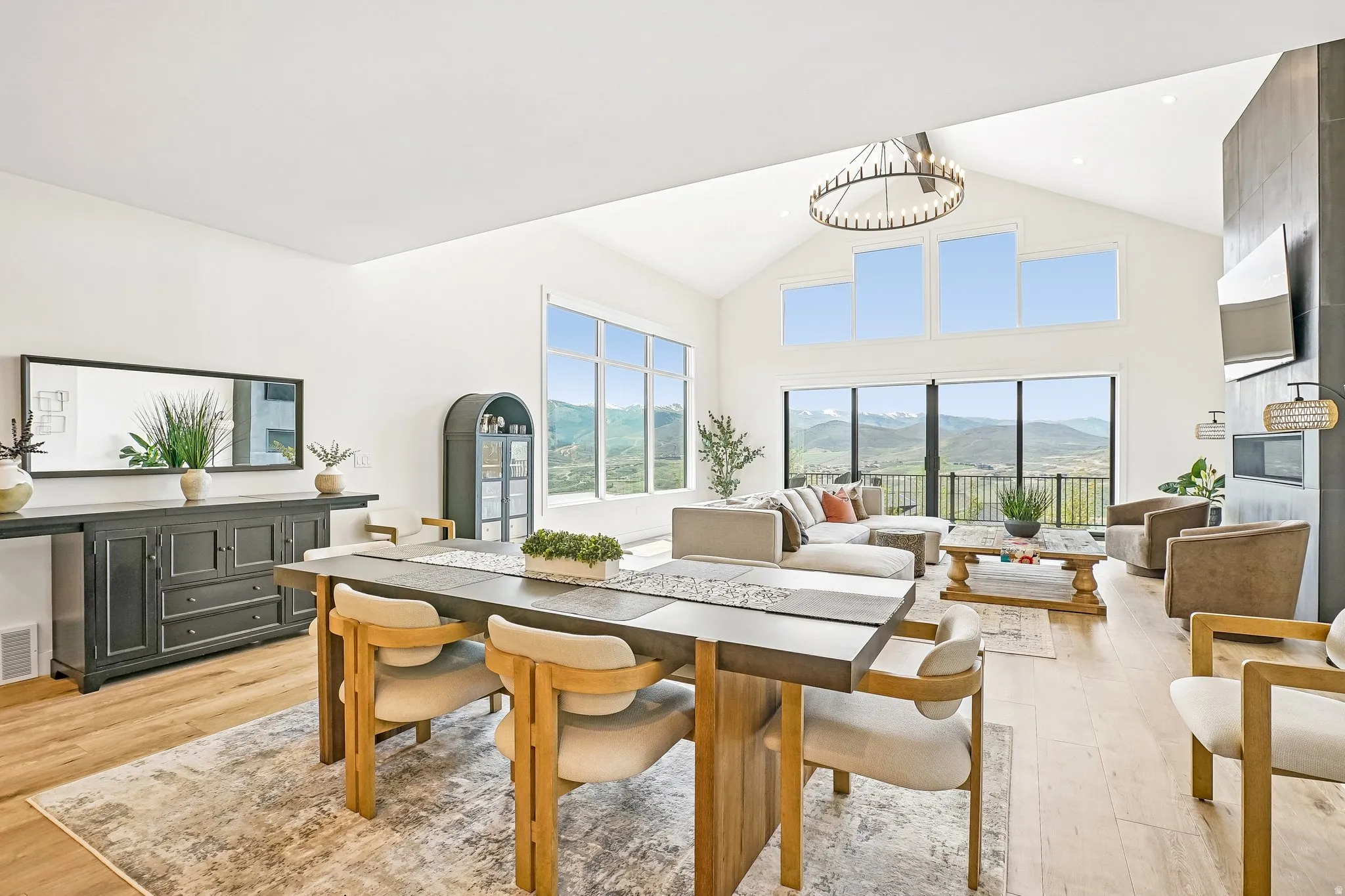 Expansive open-concept living area featuring a vaulted ceiling and wood-finish flooring