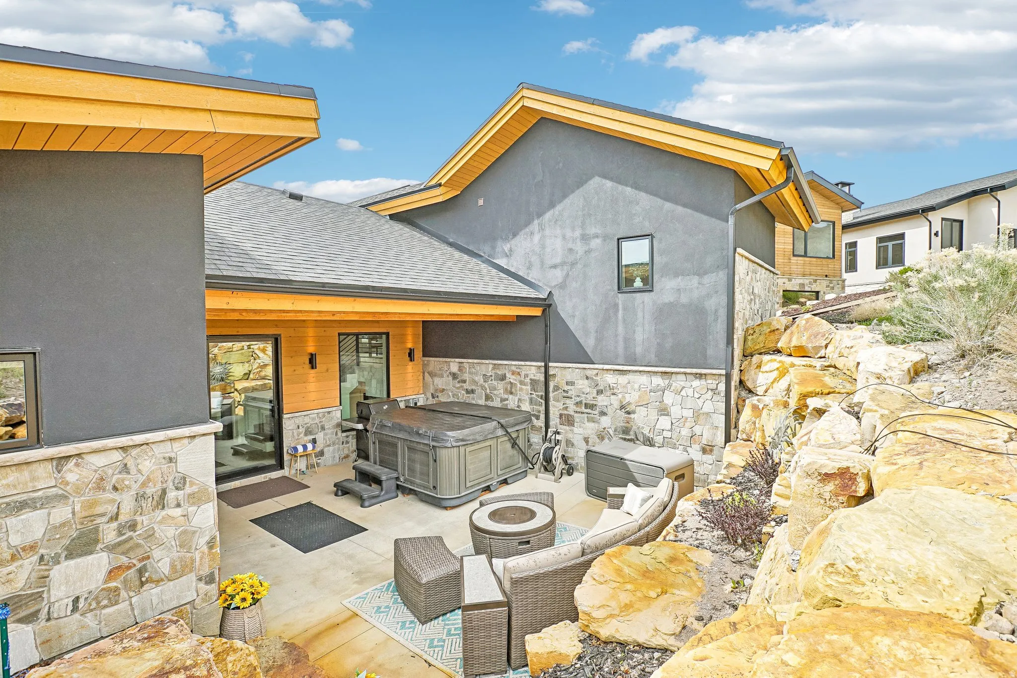 Private patio area featuring a built-in hot tub, concrete paving, and stone retaining walls