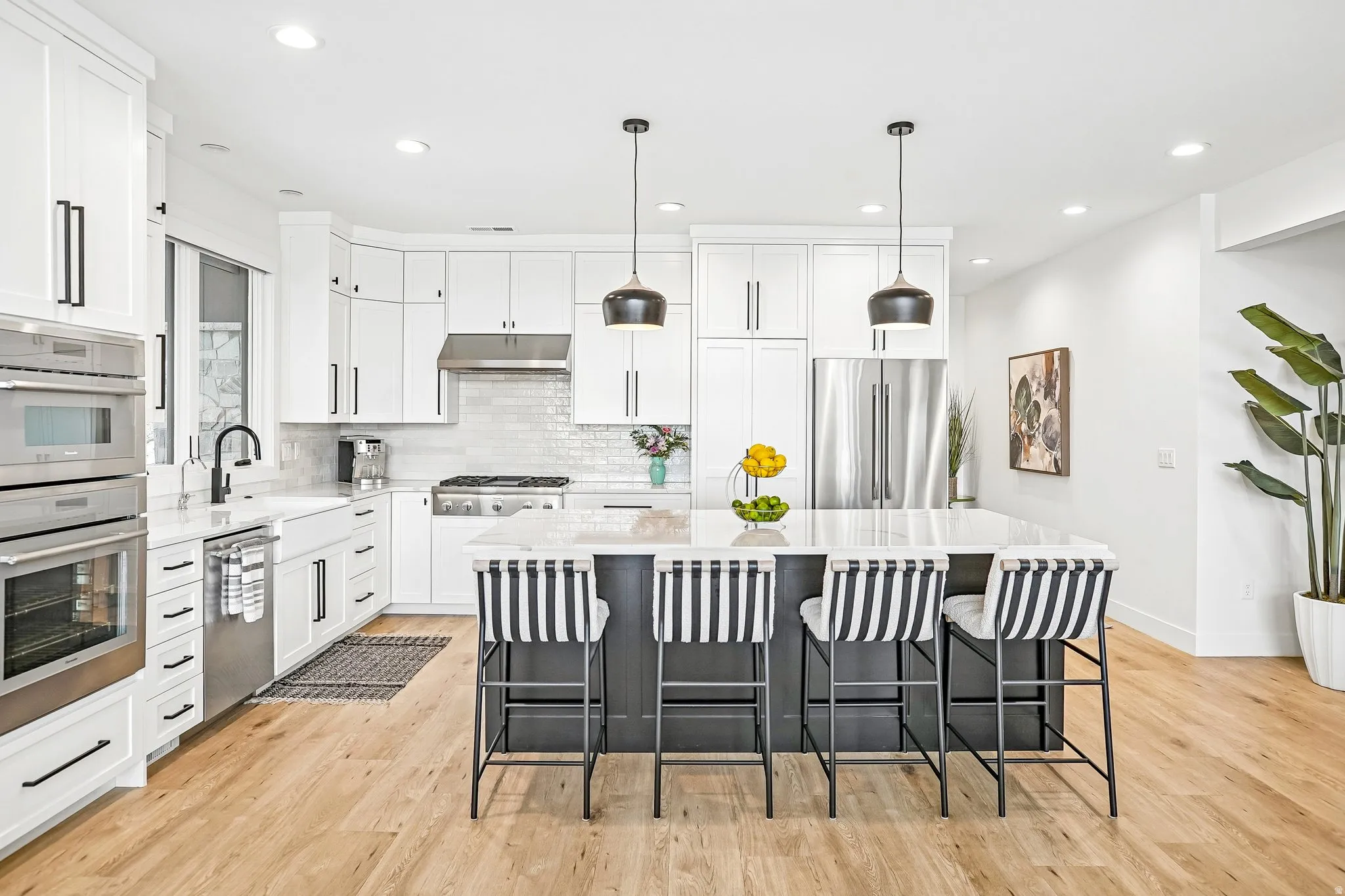 Bright kitchen featuring white cabinetry, stainless steel appliances, and a large central island