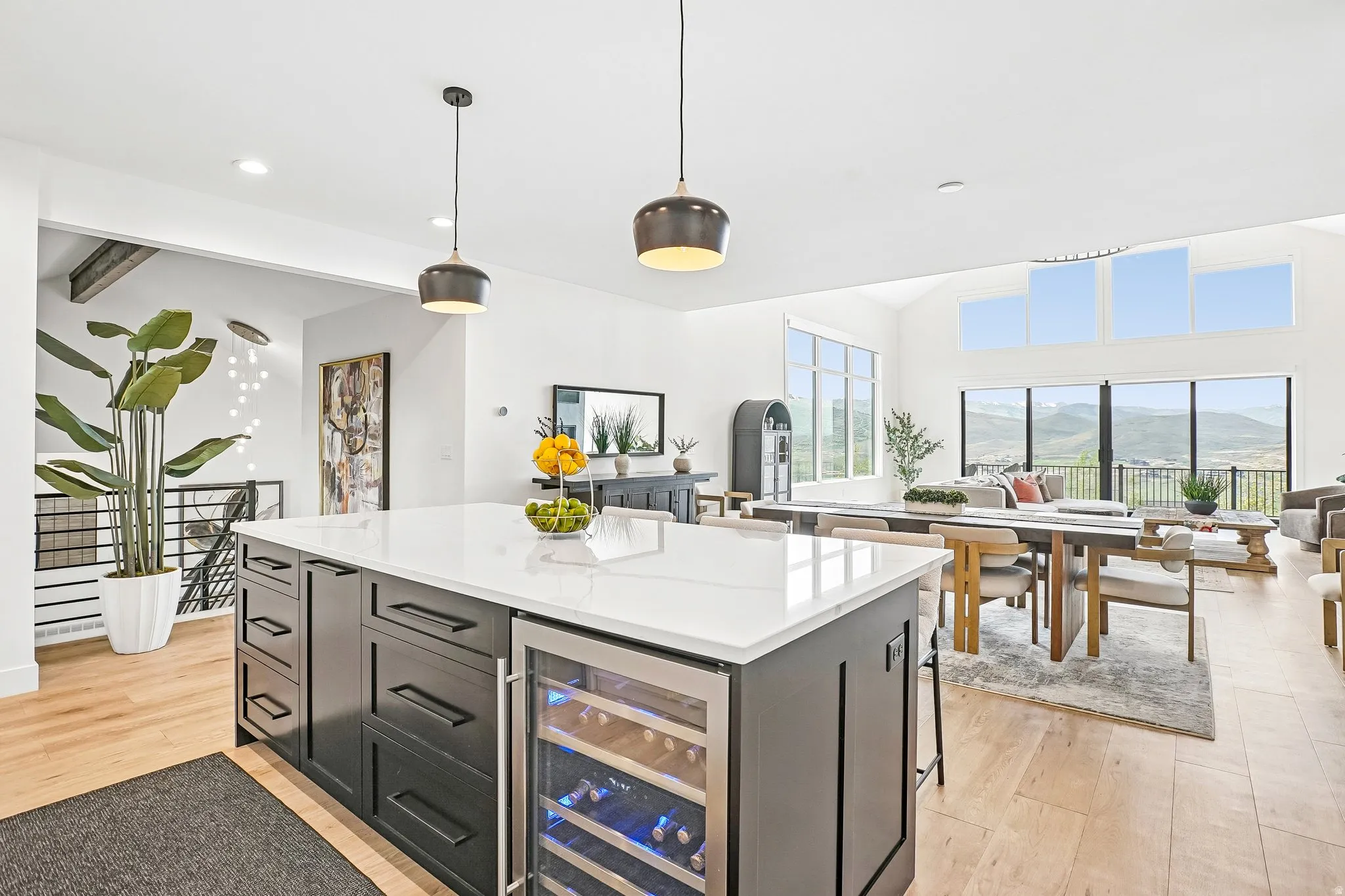 Expansive kitchen island featuring a white countertop, dark cabinetry, and an integrated beverage cooler
