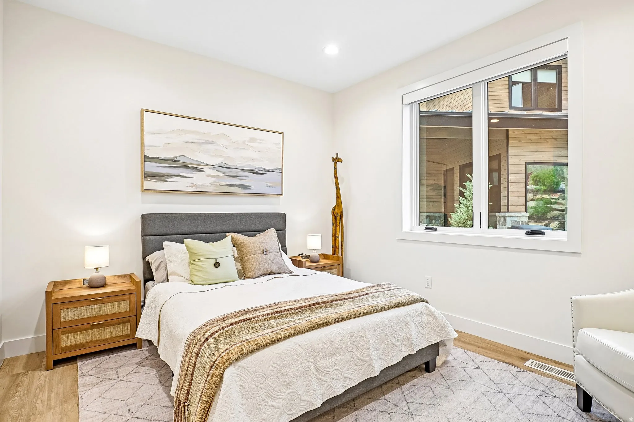 Spacious room featuring wood-finish flooring and a large window with white trim