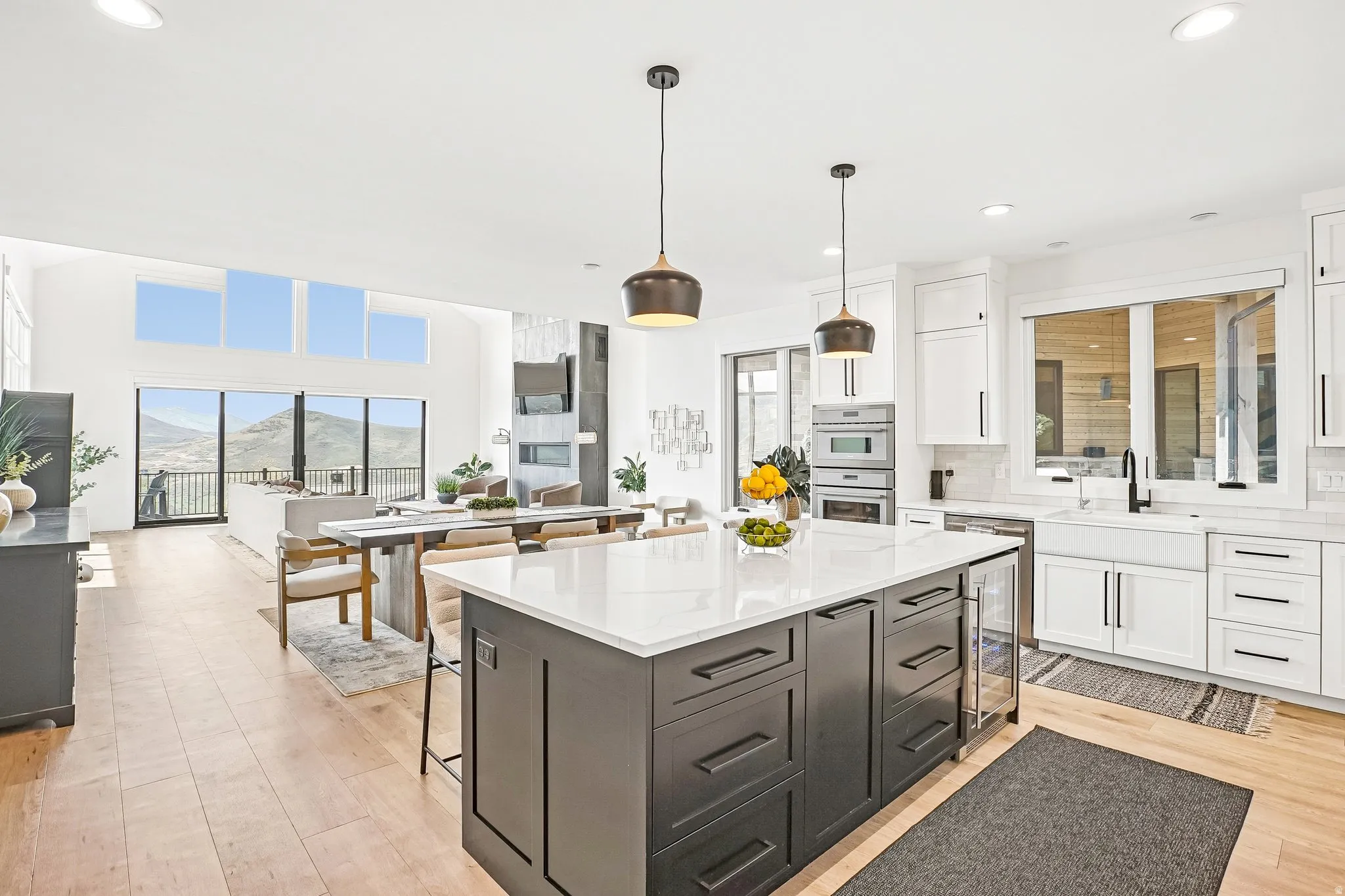 Modern kitchen featuring a large central island with a built-in wine cooler, white quartz countertops, and dual-tone cabinetry