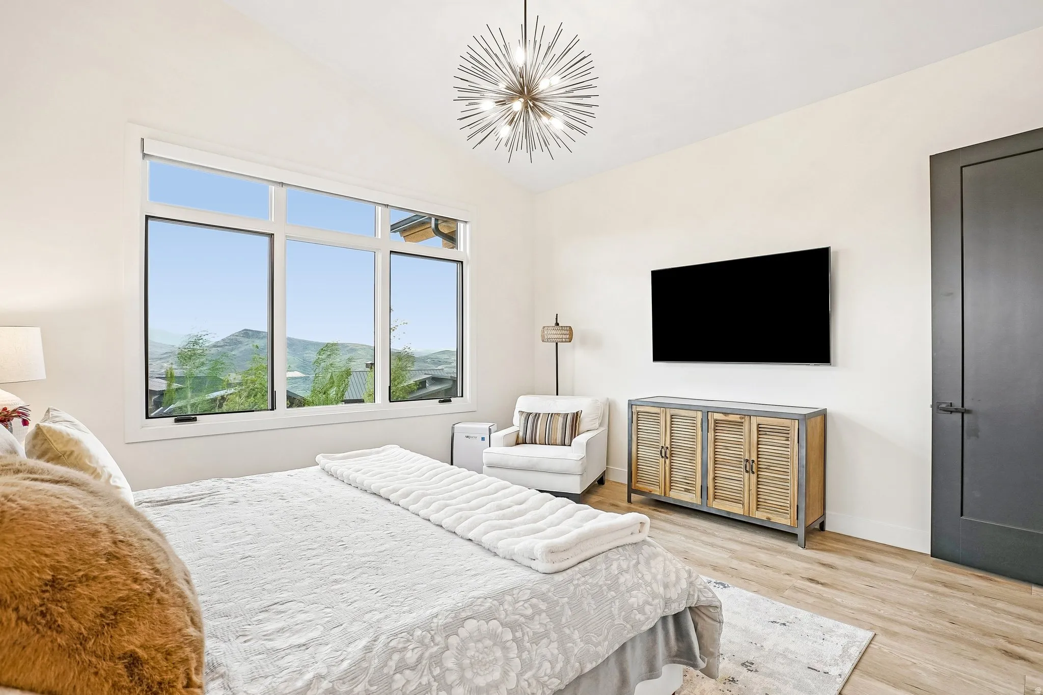 Expansive window offering a mountain backdrop, complemented by a contemporary sputnik chandelier