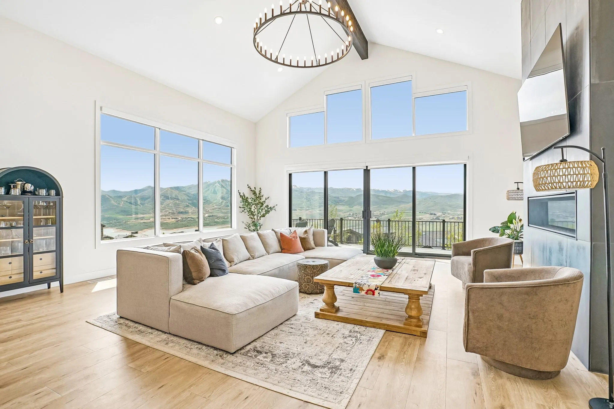 Great room featuring vaulted ceilings, wood-finish flooring, and a large multi-pane window array