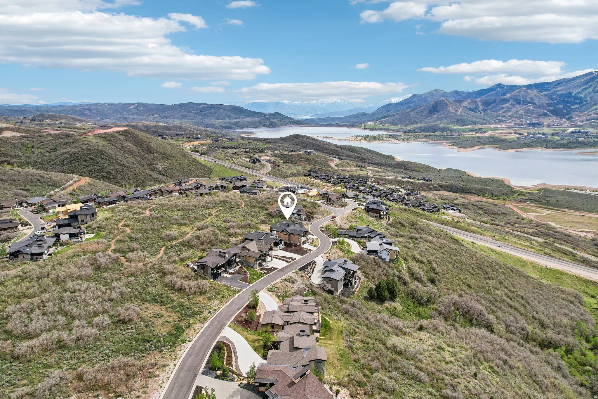 Hillside property with a winding paved road, surrounded by natural vegetation
