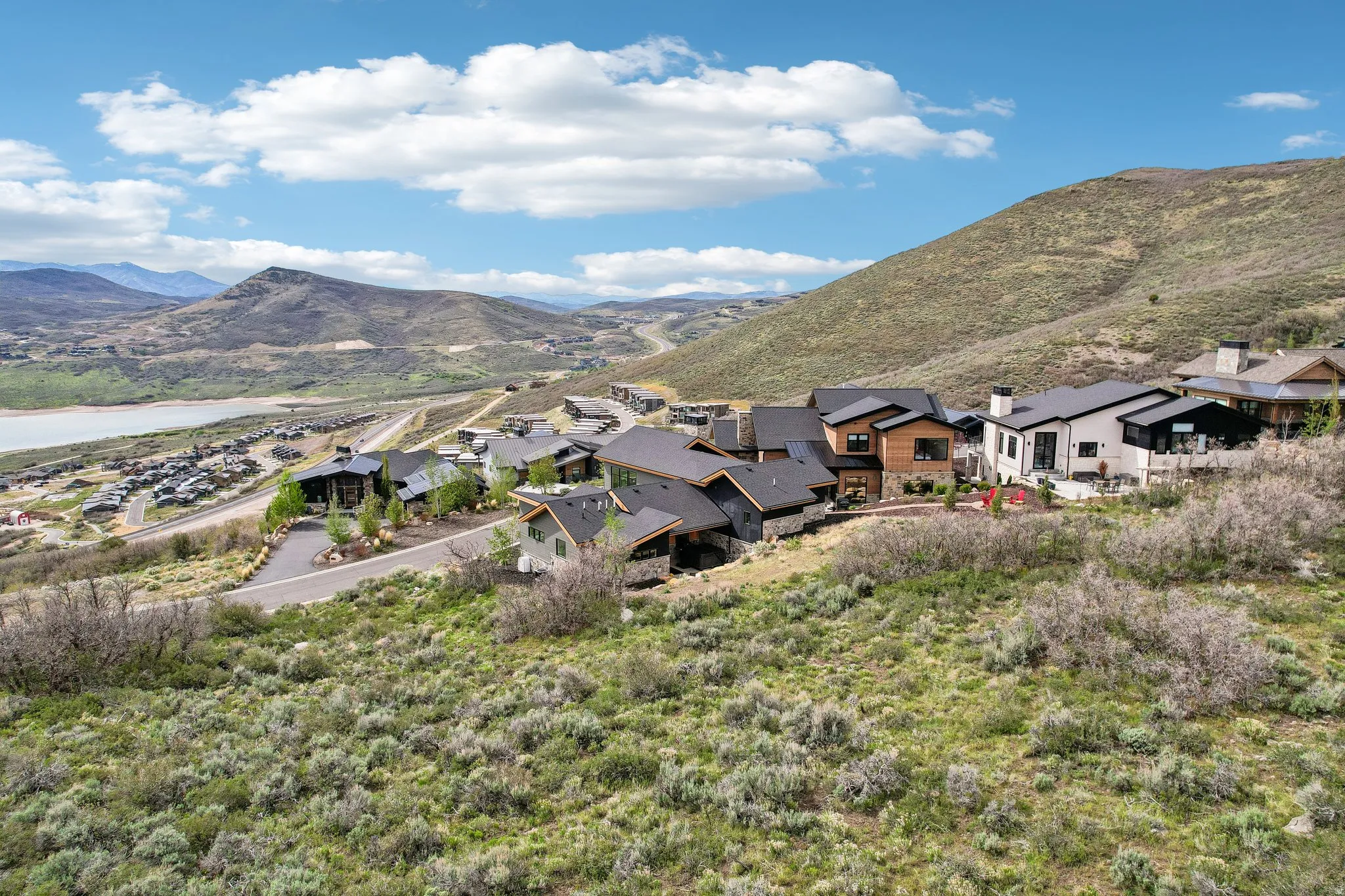 Mountain landscape with residential properties, featuring a lake and distant mountains