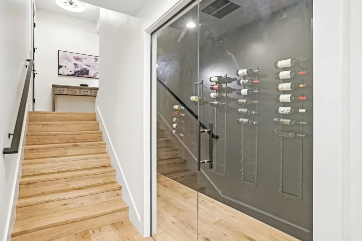 Custom glass-enclosed wine storage featuring wall-mounted racks