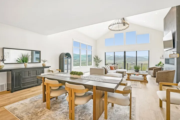 Expansive open-concept living area featuring a vaulted ceiling and wood-finish flooring