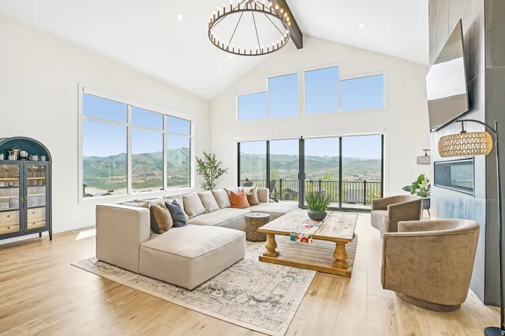 Great room featuring vaulted ceilings, wood-finish flooring, and a large multi-pane window array