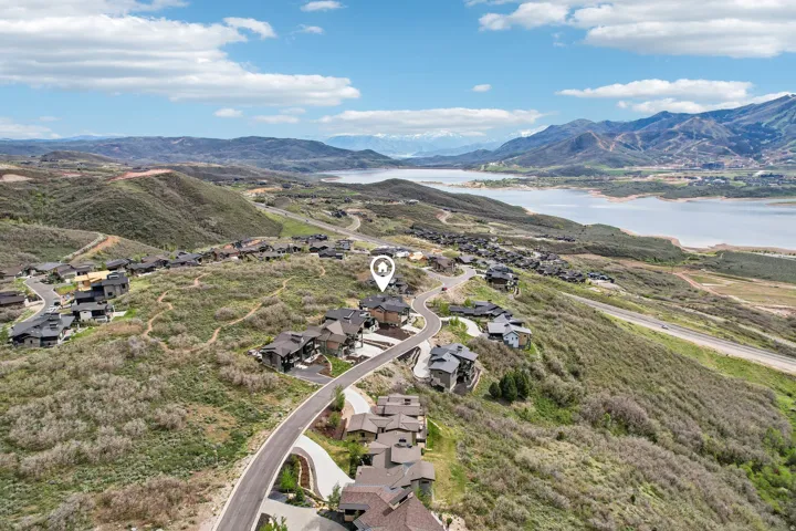 Hillside property with a winding paved road, surrounded by natural vegetation