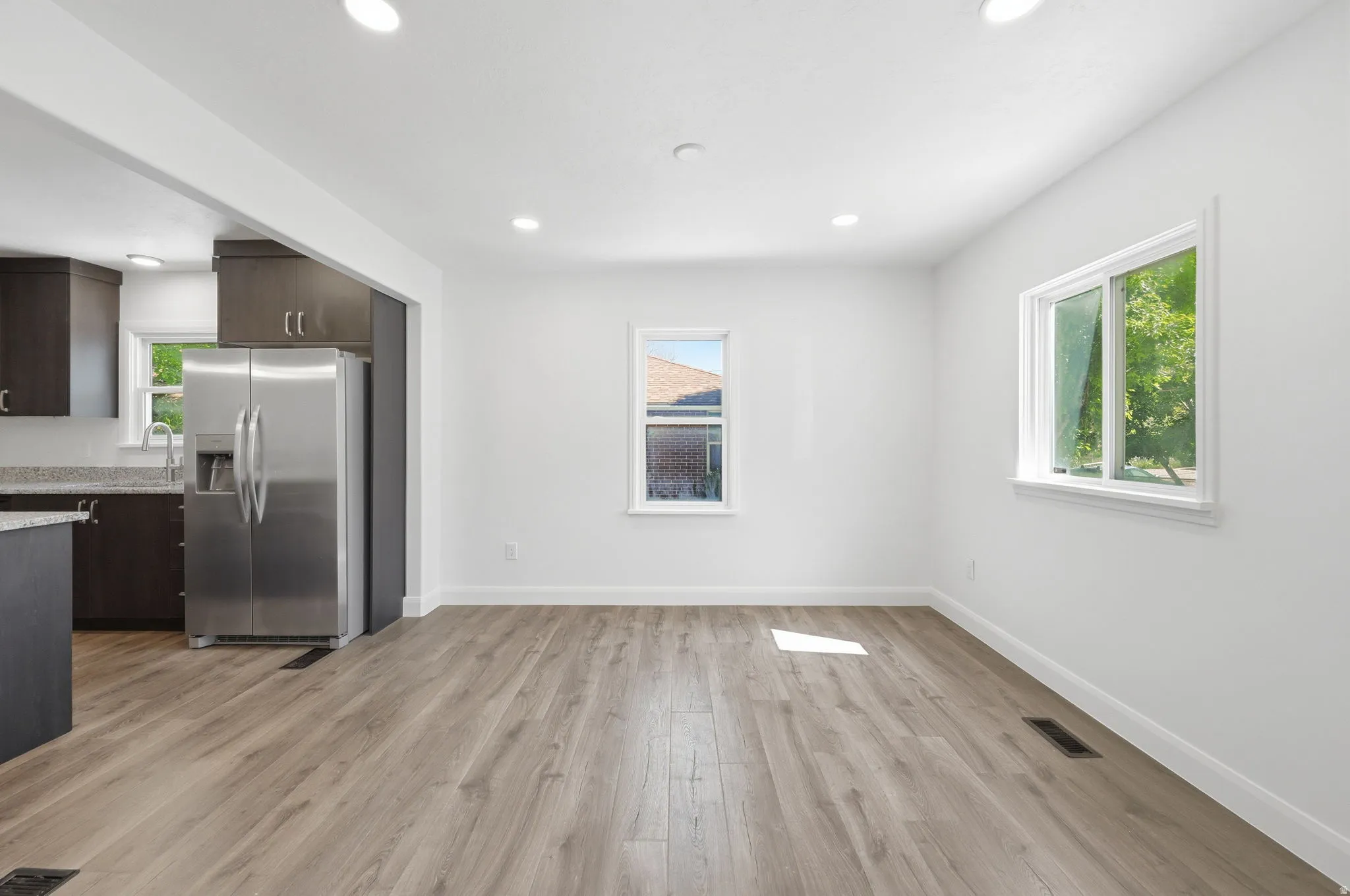 Open concept living space featuring wood-finish flooring and recessed lighting