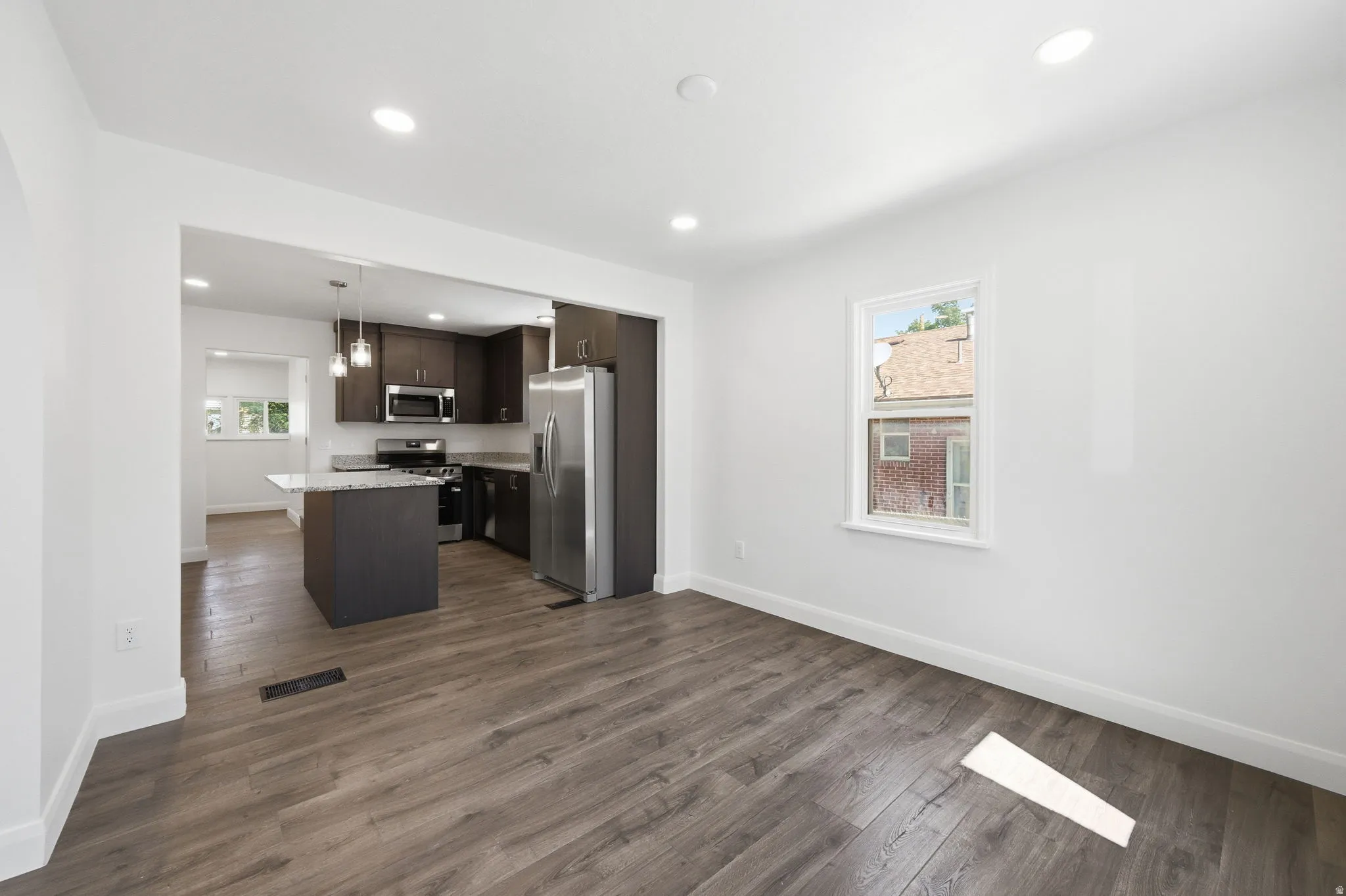 Open concept living space featuring wood-finish flooring and recessed lighting