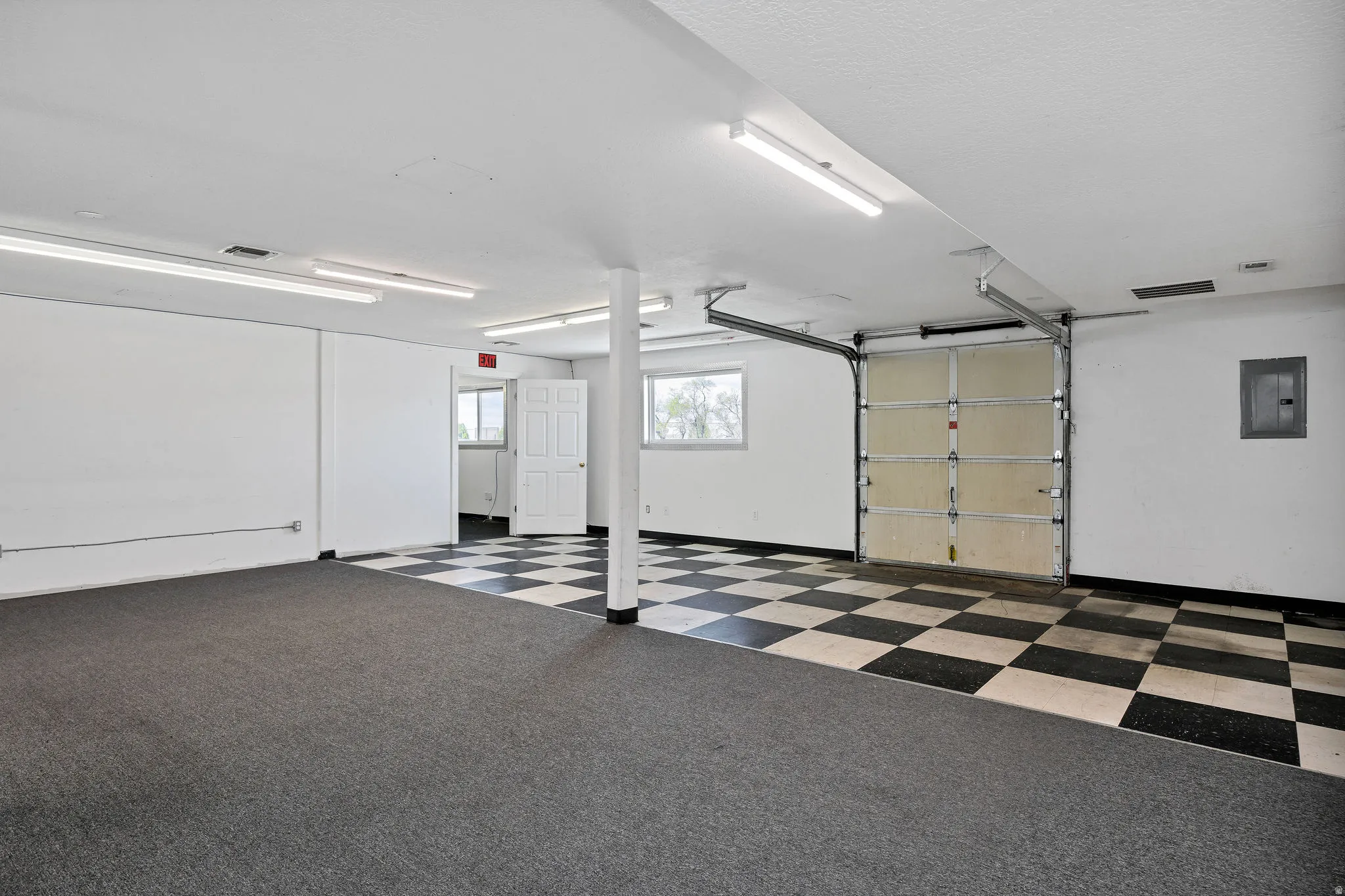 Spacious multi-purpose room featuring a combination of carpet and checkerboard tile flooring