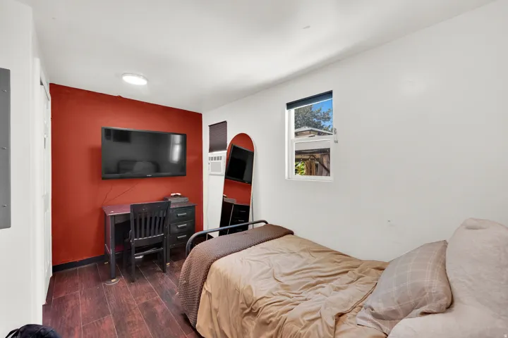Interior space featuring wood-finish flooring, a white ceiling with a flush-mount light fixture, and a window with natural light