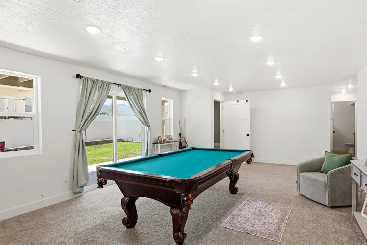 Spacious secondary living area featuring plush carpet, recessed lighting, and white walls