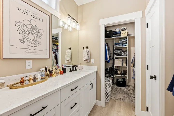 Double vanity with white cabinetry, matte black hardware, and an integrated countertop