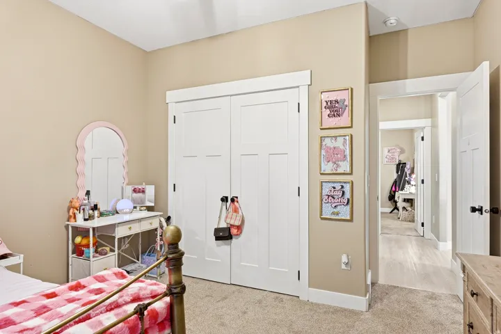 Bedroom featuring a neutral wall color, white trim, and a double-door closet with black hardware