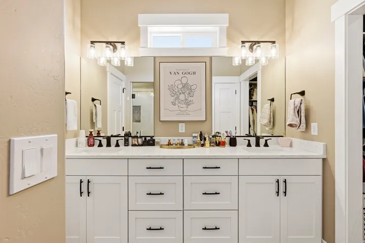 Dual vanity with white cabinetry and dark hardware
